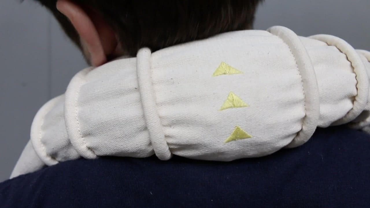 gros plan sur la nuque d'un jeune homme se massant avec le petit rouleau