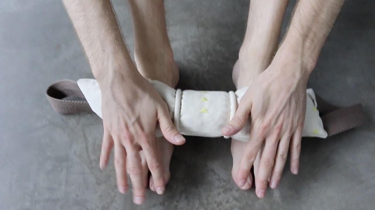 un jeune homme se masse les pieds avec le petit rouleau